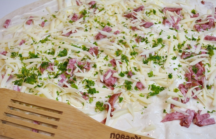 1. Этап. Жареный лаваш с колбасой и сыром: Измельченной зеленью посыпьте весь лаваш. Присолите и приправьте специями.