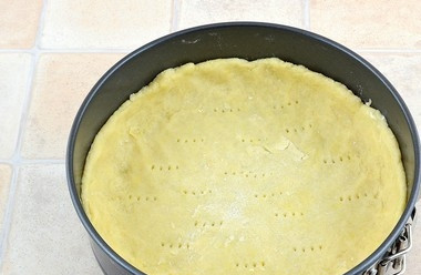 1. Этап. Пирог из песочного теста с замороженными ягодами: Тесто раскатайте в виде круга в диаметр немного больше, чем форма для выпечки. Сделайте бортики. Тесто наколите вилкой. Оставьте его в холодильнике на 30 минут.