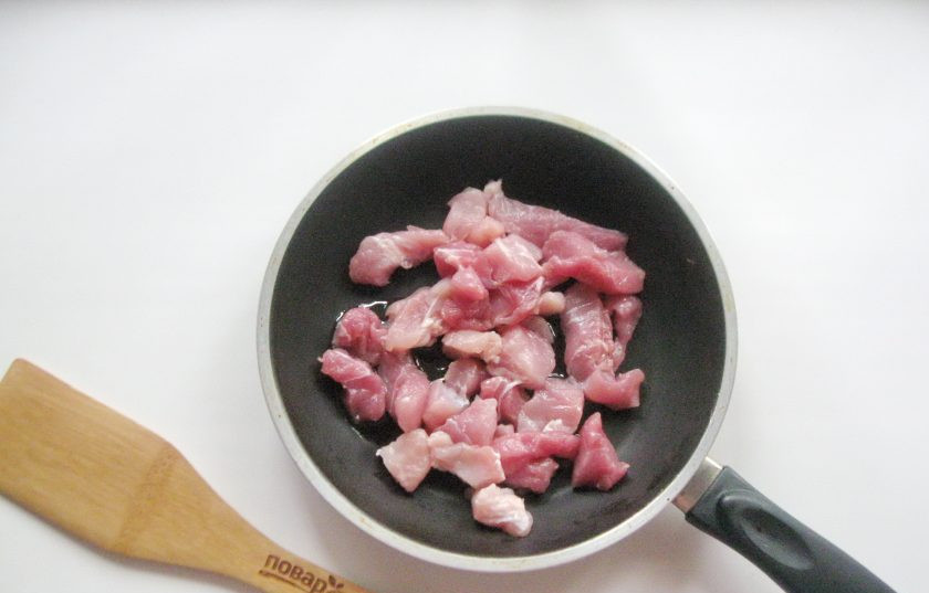 1. Этап. Корейская окрошка Кукси: Свинину помойте и нарежьте мелко. Выложите в сковороду с подсолнечным маслом.