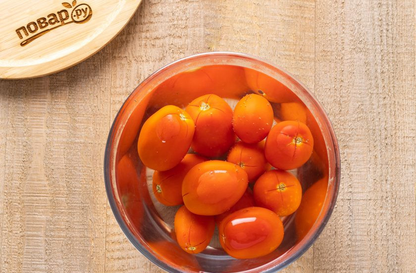 1. Этап. Баклажаны 5 овощей на зиму: Томаты промойте, сделайте надрез крест-накрест у плодоножки. Залейте кипятком и оставьте на пару минут.