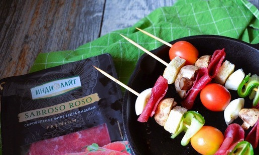 1. Этап. Закуска-перекус на шпажках: Ломтики сыровяленного филе разрезать пополам, яйцо почистить и отломить кусочки белка. Нанизать на шпажки кубики хлеба, огурец, мясо индейки, грибы, белок яйца, черри.