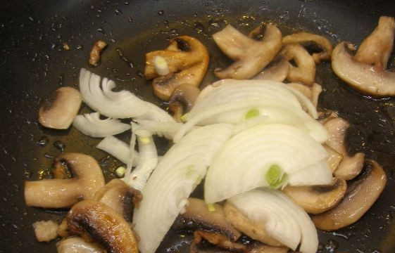 1. Этап. Салат с пекинской капустой и свежими грибами: Как грибы подрумянятся, добавьте к ним лук. Обжарьте ингредиенты вместе на максимальном огне в течение 3-х минут.