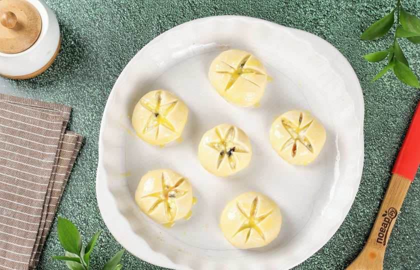 1. Этап. Пирожные Лотосы с творогом и сухофруктами: Переложите заготовки в смазанную маслом жаропрочную форму и смажьте желтком. Выпекайте в духовке при температуре 180 градусов около 30 минут.