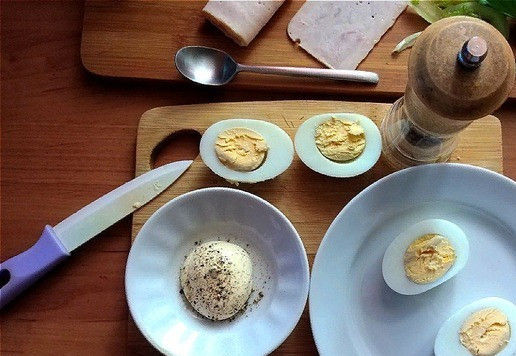 1. Этап. Яичный сэндвич: Чтобы яйца, лёжа на боку, были устойчивые их тёплыми нужно почистить и уложить на бок, немного прижав или срезав чуть у бочкА белок. Разрезаем яйца на 2 части (см. фото). Майонез я немного поперчу чёрным свежемолотым перцем.