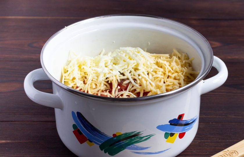 1. Этап. Паста с козьим сыром и помидорами: Добавьте половину тертого сыра. Аккуратно всё перемешайте и потомите на медленном огне 3-4 минуты.
