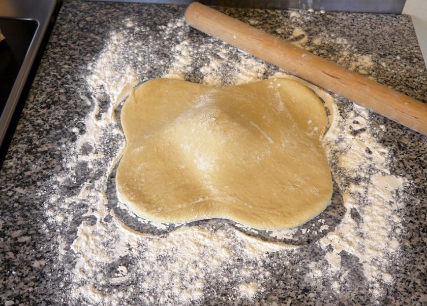 1. Этап. Плюшки Улитки: 2. Выложите тесто на стол, присыпанный мукой, и растяните его руками в 4 стороны.