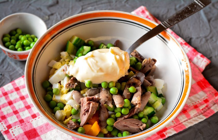 1. Этап. Салат с куриными сердечками и горошком: Отправьте в миску все нарезанные ингредиенты, добавьте зеленый горошек и майонез. Посолите и поперчите по вкусу.