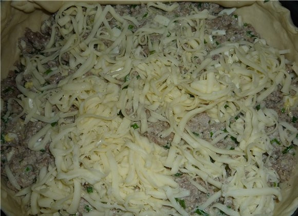 1. Этап. Пирог с мясом из слоеного бездрожжевого теста: Дальше выкладываем начинку из сковороды и посыпаем тертым сыром.