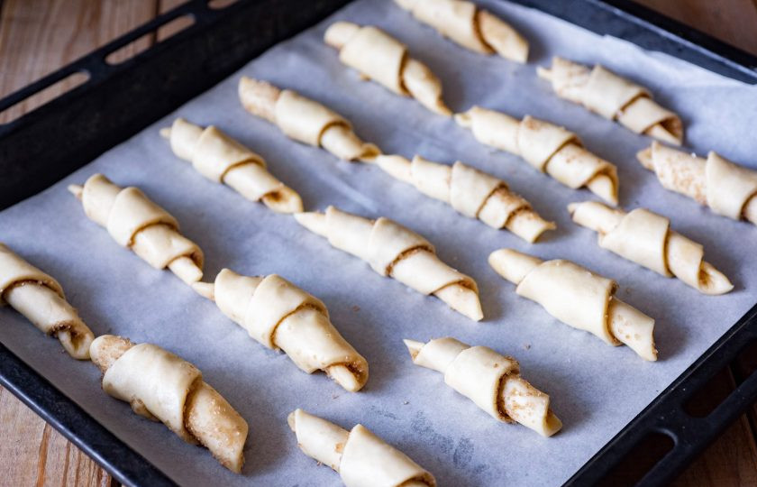 1. Этап. Рогалики с корицей: Противень застелите пергаментом для выпекания и выложите все заготовки будущих рогаликов. При желании можно смазать поверхность каждой заготовки смесью взболтанного желтка и 1 ч.л. воды. Выпекайте рогалики в уже разогретой до 180 градусов духовке в течение 15 минут.