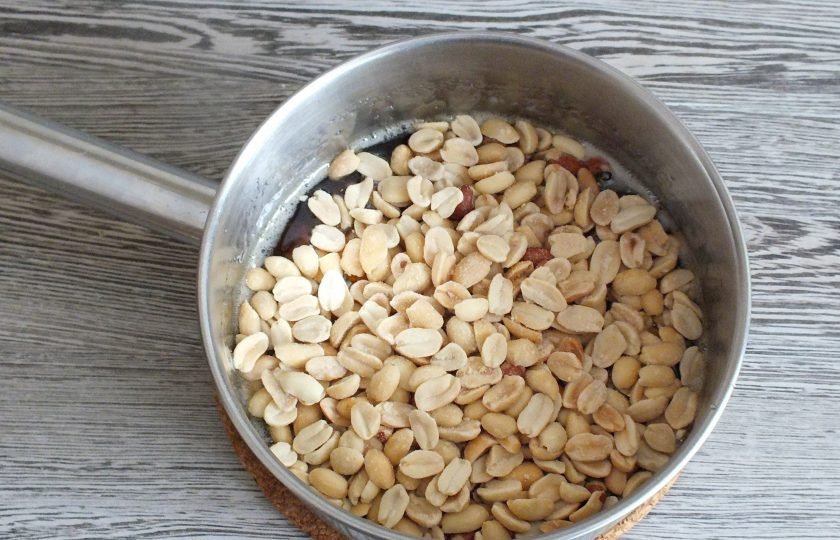 1. Этап. Тарталетки с орехами и карамелью: В карамель всыпьте орехи. Перемешайте, проварите 2 минуты. Снимите с огня.