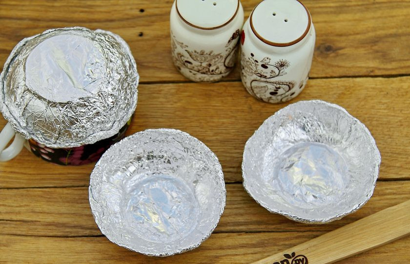 1. Этап. Яйца на гриле: Из фольги сделайте формочки с невысокими бортиками. Диаметр формочек должен соответствовать размеру яиц. Для удобства можно воспользоваться кружкой или стаканом. Сверните кусок фольги в 2-3 слоя и оберните кружку снизу. Затем аккуратно снимите и уже руками сформируйте небольшие бортики по кругу. Смажьте формочки растительным маслом.