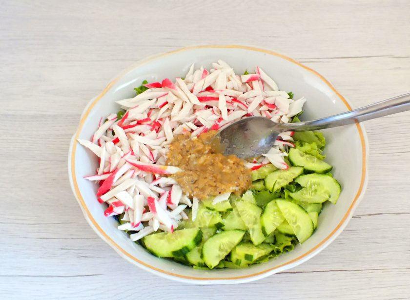 1. Этап. Салат с крабовыми палочками и рукколой: Заправку добавьте в салатник. Посолите по вкусу.