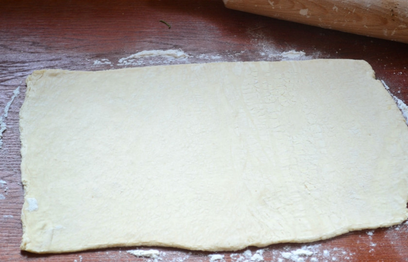 1. Этап. Пирог с начинкой из сыра и ветчины: Все тесто разделите пополам. Одну часть раскатайте толщиной примерно в 2-3 мм.