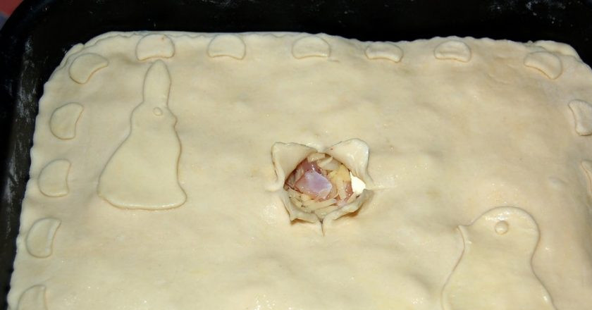 1. Этап. Курник из слоёного теста: 2. Раскатайте второй лист слоеного теста и закройте им начинку, подверните края и скрепите их. Из остатков теста сделайте украшения и с помощью желтка прикрепите их. Смажьте желтком весь пирог, так у вас получится красивая корочка. В центре сделайте глубокий надрез.