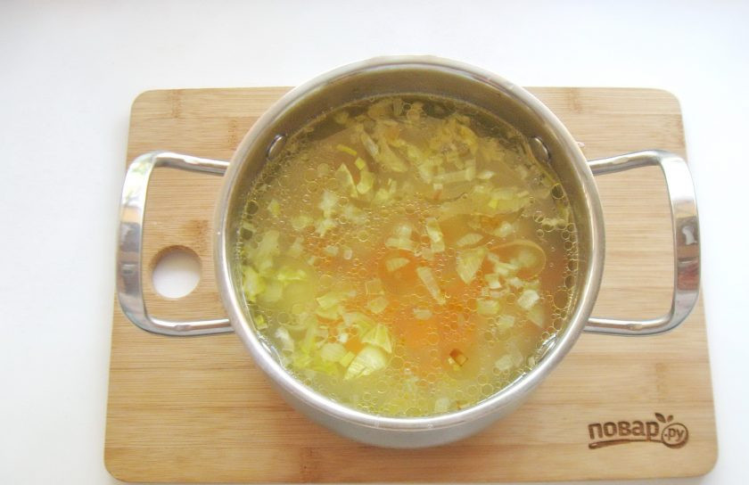 1. Этап. Уха из пеленгаса: Лук с морковью выложите в кастрюлю с ухой.