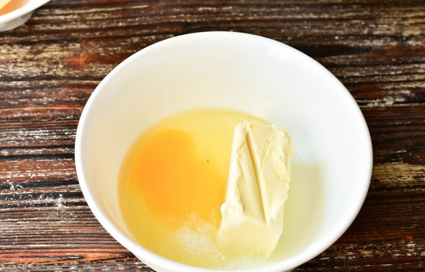 1. Этап. Сырные хрустики: В миску вбейте яйцо. Выложите сливочное масло и всыпьте соль.