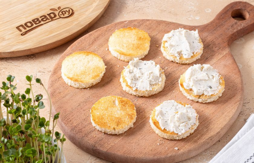 1. Этап. Канапе с огурцом и сыром: Смажьте кружочки хлеба творожным сыром.