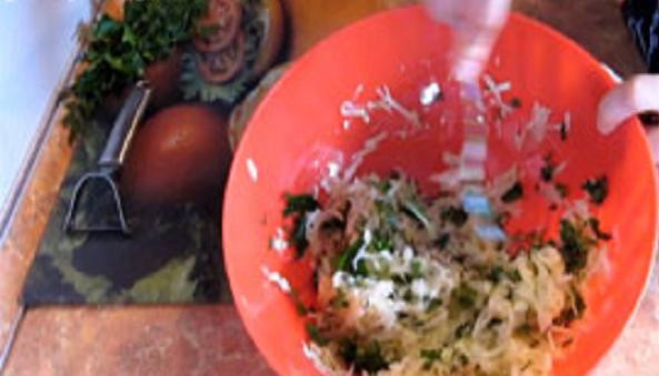 1. Этап. Кабачковые оладьи без яиц: Отжимаем кабачки и смешиваем их с зеленью.