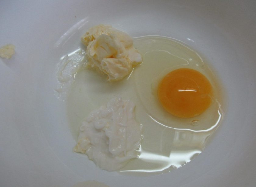 1. Этап. Закусочный кекс с кукурузой, колбасой и пармезаном: Яйцо перемешать с йогуртом и мягким сливочным маслом.