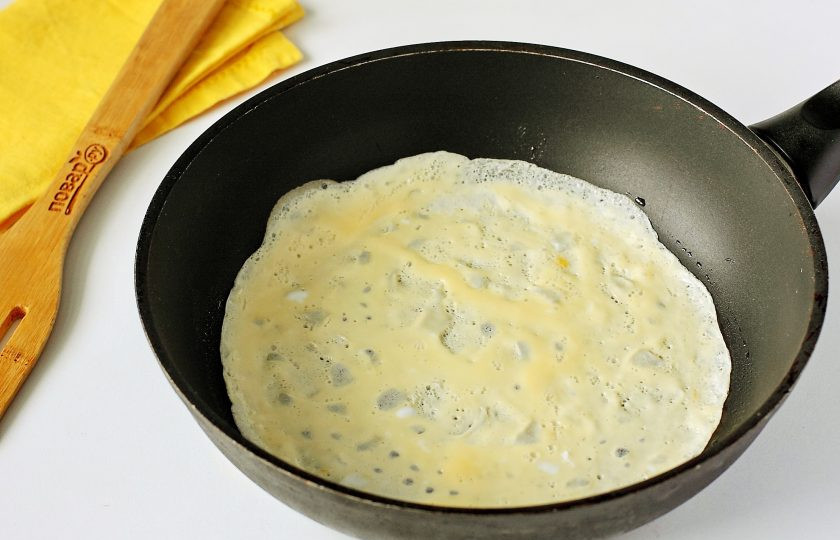 1. Этап. Яичные блинчики без крахмала: Разогрейте сковороду и смажьте ее маслом. Вылейте тонкий слой яичной смеси и на среднем огне сначала обжарьте одну сторону.