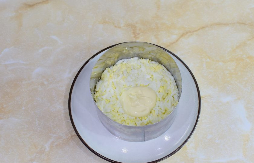 1. Этап. Салат с курицей, сыром и маринованными грибами: Яйца потрите на терке и выложите следующим слоем салата. Так же смажьте слои небольшим количеством майонеза.
