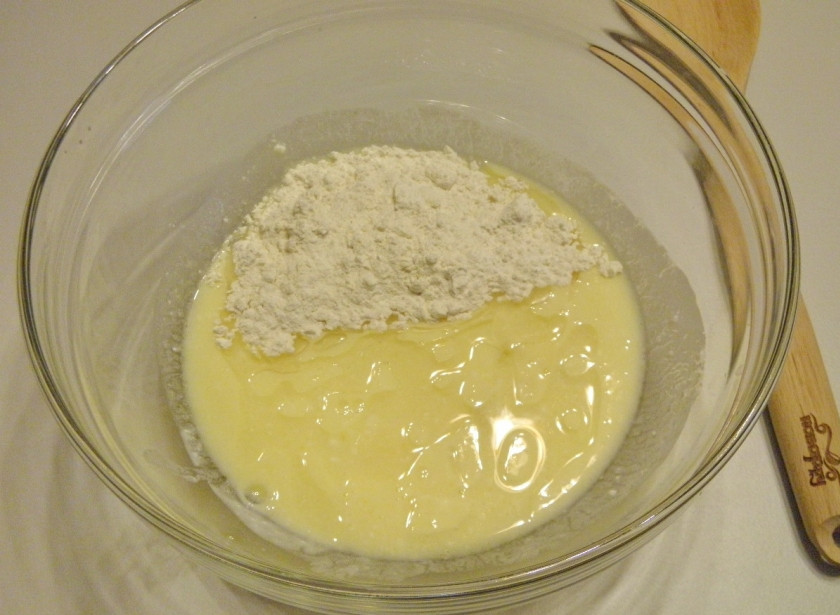 1. Этап. Пышки на кефире, жаренные на сковороде: Влейте кефир, размешайте. После добавьте масло и муку, соду, начните замешивать тесто.