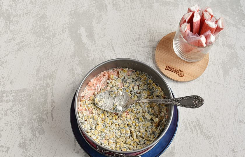 1. Этап. Крабовый салат с рисом и кукурузой: Затем смешайте кукурузу с укропом и ложкой майонеза. Выложите очередным слоем.