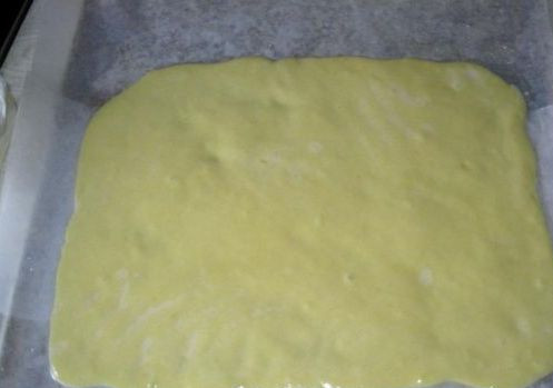 1. Этап. Рулет за 5 минут: Далее мы застилаем противень пергаментной бумагой и смазываем ее маслом, выкладываем на бумагу тесто и распределяем его по всей поверхности так, чтобы получился небольшой прямоугольник.