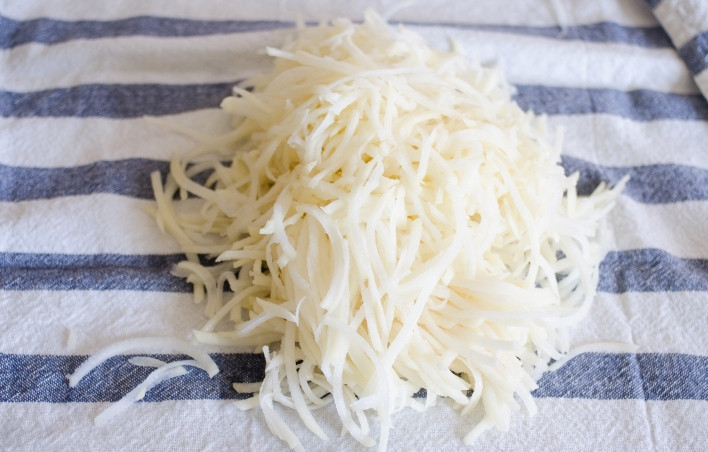 1. Этап. Драники (вариант для ленивых): 4. Переложите на чистое полотенце, заверните и выжмите хорошо остатки жидкости.