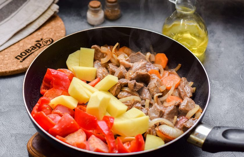 1. Этап. Шурпа с телятиной: В сковороде прогрейте масло, жарьте мясо, лук и морковь 4 минуты, после добавьте перец, томаты и картофель.