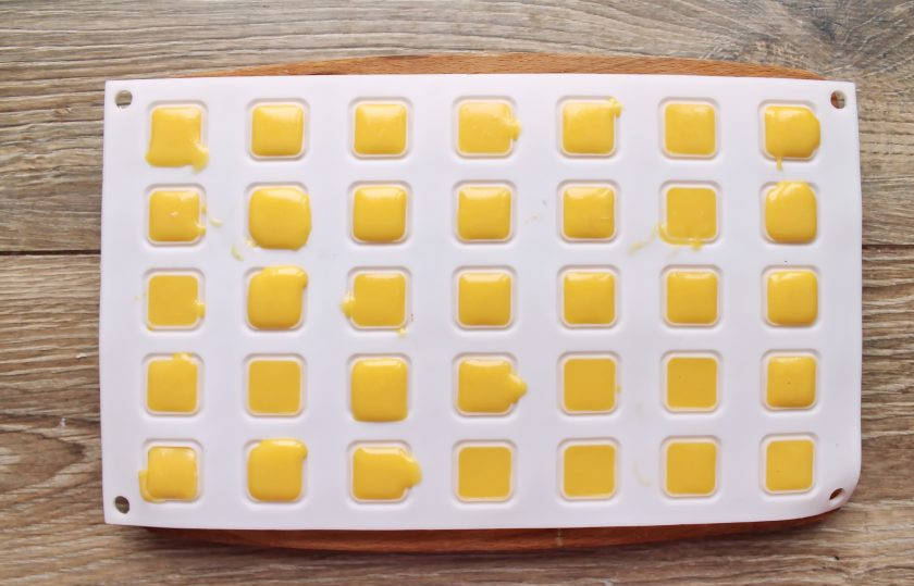 1. Этап. Конфеты с манго: Остудите массу до теплого состояния и разлейте по ячейкам формы для конфет.