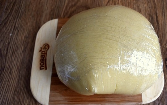 1. Этап. Медовое пирожное с начинкой: Вылейте смесь в муку, замесите тесто, не липнущее к рукам, с помощью миксера, насадками для теста. Тесто получается достаточно мягким, но при остывании хорошо держит форму и остается пластичным. Тесто заверните в пищевую пленку и оставьте в холодильнике на 20 минут.