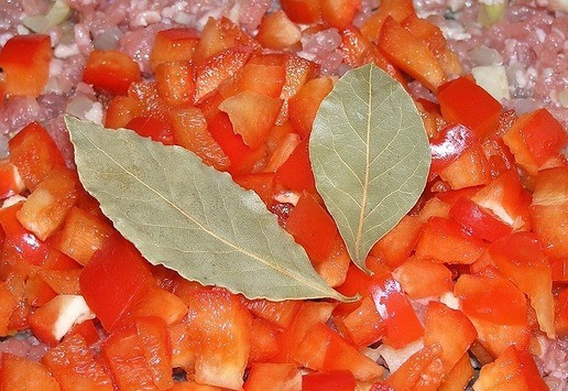 1. Этап. Аргентинский пирог с фаршем: Добавьте свиной фарш, затем мелко нарезанный сладкий перец, лавровые листы, бульонные кубики, посолите, поперчите, перемешайте, и добавьте горячую воду, едва покрыв ею мясо.