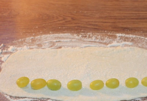 1. Этап. Творожное печенье с виноградом кишмиш: 9. Раскатываем каждый шарик в длинную и тонкую лепешку (толщ. 1-2 мм). Посыпаем сахаром и раскладываем цепочкой виноград.