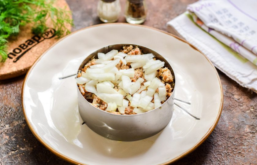 1. Этап. Салат Мимоза на Новый год Быка 2021: Поверх рыбы выложите нарезанный кубиками лук.