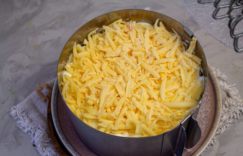 1. Этап. Салат с копченой курицей, черносливом и грецкими орехами: Поверх яичного слоя натрите сыр.