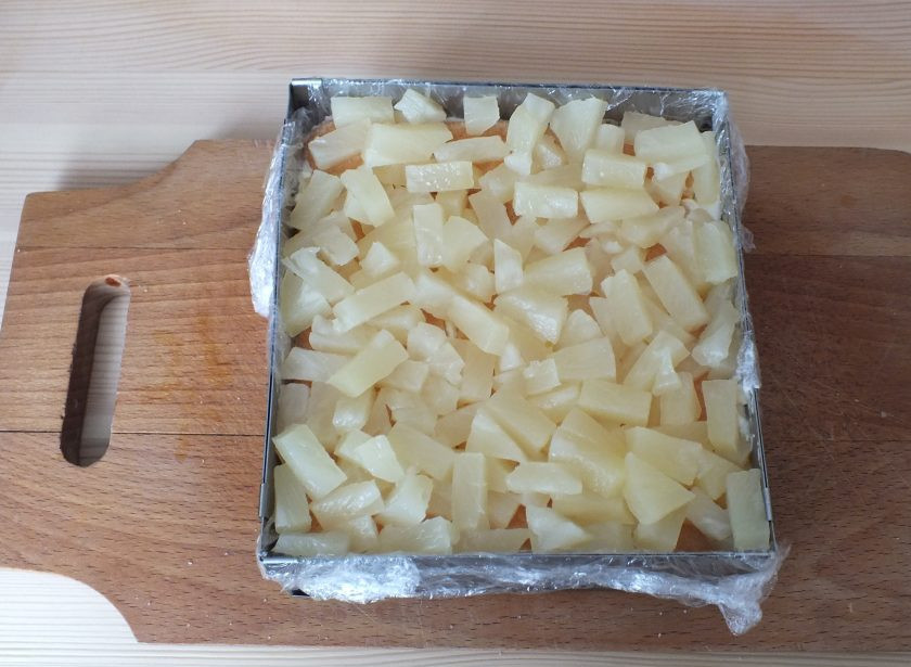 1. Этап. Торт из печенья савоярди: На слой печенья разложите нарезанные ананасы.