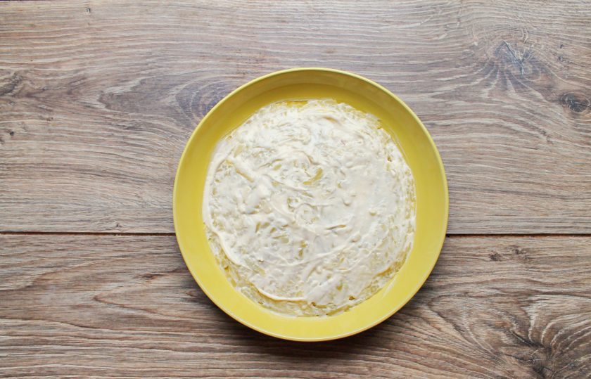 1. Этап. Селёдка под шубой с двумя видами рыбы: Картофель натрите на крупной терке и выложите ровным слоем в сервировочное блюдо или салатник. Смажьте верх слоем майонеза.