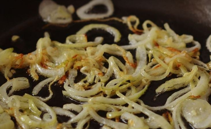 1. Этап. Легкий мясной салат: Лук очистите от шелухи, нарежьте его полукольцами. В сковороде разогрейте растительное масло, обжарьте на нем лук до золотистого цвета.