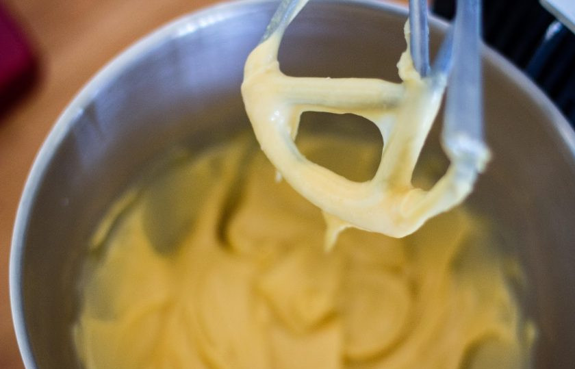 1. Этап. Профитроли с творожным кремом: Удалите тесто из кастрюли и слегка остудите. Взбивайте тесто с помощью кухонного комбайна на средней скорости в течение минуты. Так тесто быстрее остынет. Добавляйте яйца по одному. Вы заметите, что текстура теста меняется после добавления каждого яйца. Оно должно стать гладким и блестящим. Увеличьте скорость блендера до максимума и взбивайте в течение еще одной минуты.