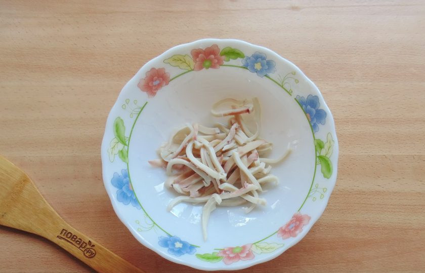 1. Этап. Салат с кальмарами и перепелиными яйцами: Кальмары очистите от пленки, удалите внутренности и хорду. Выложите в кипящую воду и варите ровно 3 минуты. После достаньте, охладите и нарежьте соломкой.