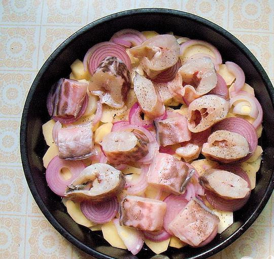 1. Этап. Конгрио с картофелем: 3. Растительным маслом смазываем форму для запекания, слой картофеля укладываем на дно, немного посыпаем черным перцем и солим. Маринованный лук выкладываем сверху на картофельный слой, кусочки рыбы выкладываем на маринованный лук.