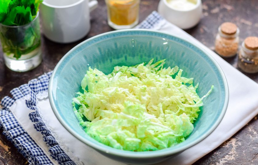 1. Этап. Салат с крабовыми палочками, креветками и ананасами: Пекинскую капусту сполосните и нарежьте соломкой, переложите капусту в салатник.