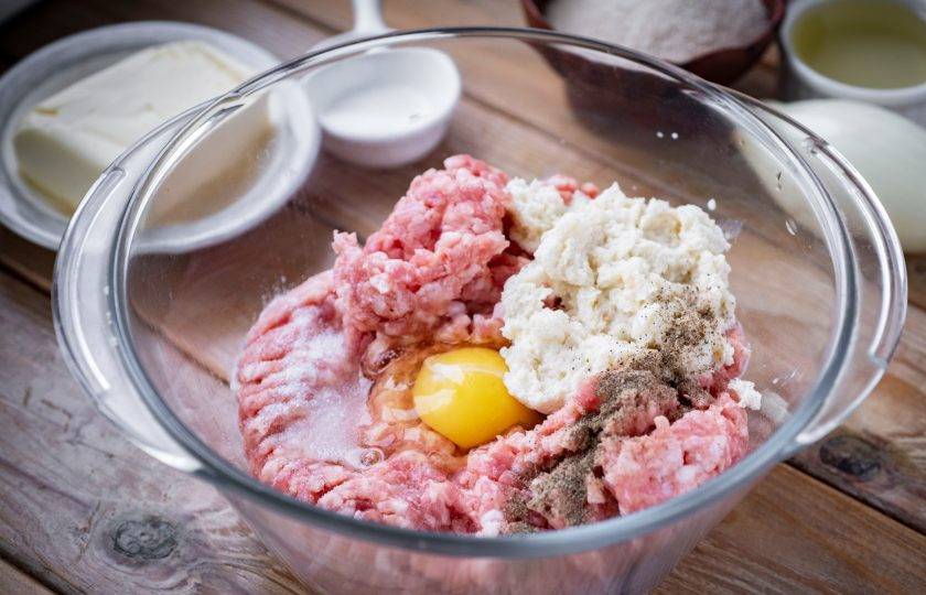 1. Этап. Котлеты Праздничные: Добавьте отжатые от молока ломтики батона, вбейте яйцо, добавьте соль и перец.