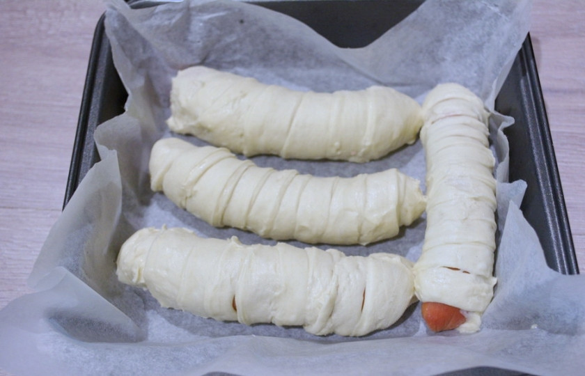 1. Этап. Сосиски в слоеном дрожжевом тесте: Сосиски очистите от пленки. Каждую сосиску оберните в полоски теста. На 1 сосиску у меня ушла 1 полоска.