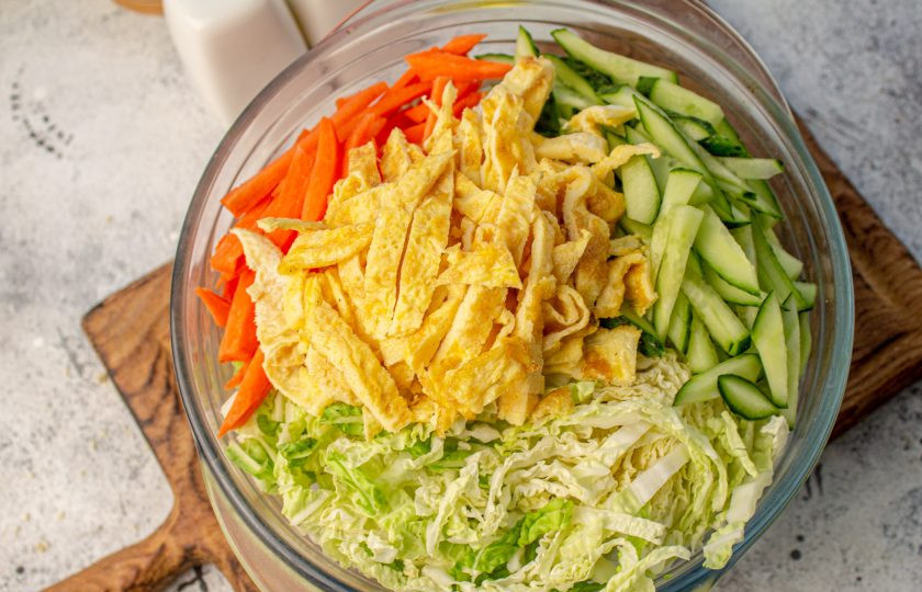 1. Этап. Салат по-китайски Харбинский: Яичные блины нарежьте на 2-4 части, а затем соломкой. Добавьте в салатник. Смешайте аккуратно все ингредиенты, при необходимости посолите и поперчите по вкусу.