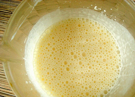 1. Этап. Луковый пирог из слоеного теста: В глубокой миске взбиваем яйца вместе со сметаной. Затем вмешиваем тертый сыр.