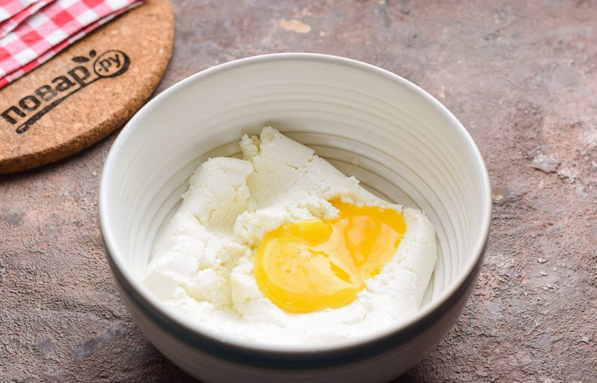 1. Этап. Сырники с хурмой: Творог переложите в миску и добавьте куриное яйцо.