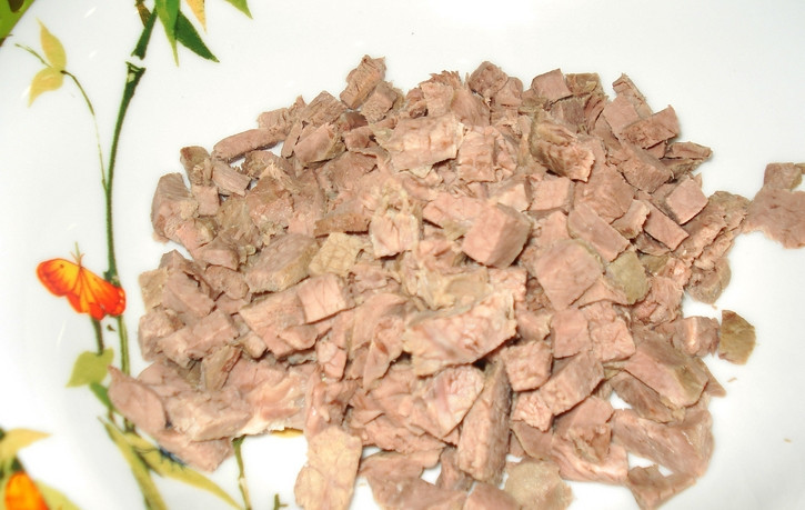 1. Этап. Салат Купеческий со свининой: Отварите кусочек свинины до готовности в кипящей, подсоленной воде. Остудите и порежьте мясо кусочками.