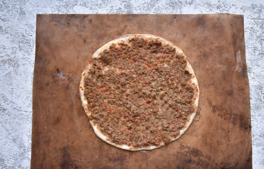 1. Этап. Лахмаджун по-турецки: Вместе с пергаментом перенесите заготовку на противень в духовку, разогретую до 230-250 градусов. Выпекайте лахмаджун 6 минут. Не пересушите!